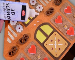 Wände des Hauses mit Lebkuchen verzieren Bild vom Verzieren der Wände des Hauses mit Lebkuchen und Kunstschnee