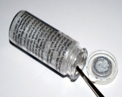 Bild von einem Pinsel der in einem Glas Silberpulver steckt