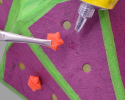 Papiersterne auf Bananenpapier kleben Bild vom Aufkleben kleiner Papiersterne auf magentafarbenes Bananenpapier