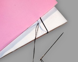 Annähen des Buchrückens Bilder vom Binden eines Bucheinbandes mit einer Nähnadel