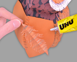 Bild vom Ankleben der Papierfedern an das Flügelgerüst der Eule