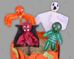 Bild von gruseligen Halloween Lutschern, welche im Dekosand stecken.