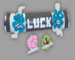 Bild von verziertem Silvester Knallbonbon mit zwei Glücksbringern aus Papier