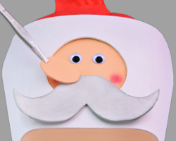 Nikolausgesicht auf Geschenkverpackung kleben Bild vom Aufkleben des Nikolausgesichts auf die Geschenkverpackung