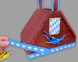 Weißblaue Bordüre an Bierzeltkorb ankleben Bild vom Ankleben der weißblauen Bordüre am Bierzeltkorb