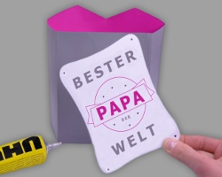 Grußkarte "Bester Papa der Welt" auf Papiersakko kleben Bild von Grußkarte mit der Aufschrift "Bester Paper der Welt", welche auf das Papiersakko geklebt wird