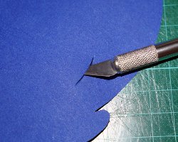 Bild von Einschnitten mit Bastelmesser in ein blaues Tonpapier