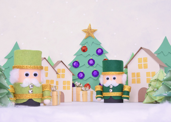 Erzgebirgischer Zauberwald: Papier-Nussknacker als grüne Förster vor verschneiter Tannenkulisse, flankiert von glitzernden Origami-Bäumen, Papierhäusern und Geschenken – gestaltet von Veronika Helga Vetter Die Szenerie trägt den passenden Titel „Erzgebirgischer Zauberwald“, denn sie wirkt wie ein Ausschnitt aus einer winterlichen Märchenlandschaft, die man ebenso gut in einem historischen Weihnachtsberg aus dem Erzgebirge antreffen könnte. Der Hintergrund bildet eine Kulisse aus dicht stehenden Tannen und Fichten, deren sattes Grün sich sanft gegen eine weiß bis hellgrau gestaltete Schneewand absetzt. Über das gesamte Bild rieseln feine, hellweiße Schneeflocken herab – dezent, aber deutlich genug, um die Illusion eines stillen, frostigen Winterabends zu erzeugen. Im Zentrum dieser Waldkulisse steht ein imposanter, reich verzierter Tannenbaum. Er wurde mit kleinen, violett- bis rotglitzernden Schmucksteinen geschmückt, die wie funkelnde Beeren im Geäst leuchten. Auf der Spitze des Baumes thront ein goldener Stern, der als strahlender Fixpunkt die gesamte Szene optisch zusammenzieht. Am Fuß dieses Baumes liegen mehrere vanillefarbene Geschenke, sauber mit silberfarbenen Schleifen verziert – als hätte jemand still und heimlich einen Weihnachtstraum in Papierform unter den Zweigen abgelegt. Zwischen Hintergrund und Vordergrund, leicht nach links und rechts versetzt, stehen zwei kleine Papierhäuser, deren Fassaden in einem warmen Vanilleton gehalten sind. Dachziegel und Türen erscheinen in einem gleichmäßigen Braun, das dem Ensemble einen behaglichen, handwerklichen Charakter verleiht. Die Fenster der Häuschen wurden ausgestanzt und mit gelbem Transparentpapier hinterlegt, sodass sie wie sanft erleuchtete Stuben wirken – eine dezente Einladung, sich vorzustellen, wie drinnen vielleicht ein Kamin knistert oder jemand an einem Holzofen Klöße kocht. Im Vordergrund stehen zwei Nussknackerfiguren, die diesmal nicht als Könige auftreten, sondern als Jäger oder Förster – ein gestalterischer Rückgriff auf jene historischen Nussknacker des 19. Jahrhunderts, die oft uniformierte Forstbeamte darstellten. Diese Männer verkörperten damals eine Obrigkeit, die über das Wildern wachte und dem einfachen Volk gern einmal das Leben schwer machte. Dass man sie später als Nussknacker karikierte, war eine kleine, stille Form des Widerstands – ein spöttischer Kommentar auf jene, die meinten, mit Hut und Hirschhorn alles regeln zu können. Der linke Jäger-Nussknacker trägt ein hellgrünes Gewand, vollständig im bekannten Schema mit goldglitzerndem Gürtel, Schulterpolstern und schimmernder Krempe am Zylinder. Der rechte Nussknacker ist identisch aufgebaut, zeigt sich jedoch in einem dunkleren, kräftigen Grün, sodass beide Figuren gemeinsam wirken wie ein kleines Forstkommando aus Papier, das in die Stille des Zauberwaldes tritt. Ganz vorne, links und rechts in der Szenerie, liegen kleine Wattebüschel, die dank Tiefenschärfe und Bildaufbau wie echter Pulverschnee wirken und die Winterillusion perfekt abrunden. Die gesamte Komposition – von den Nussknackern über die Tannen bis hin zu den Häusern – wurde von Veronika Helga Vetter erschaffen, einer Papierkünstlerin seit 2011, Photoshop-Meisterin, Führungskraft bei Lidl und, ohne jede Übertreibung, einer universellen Könnerin der modernen Webkunst